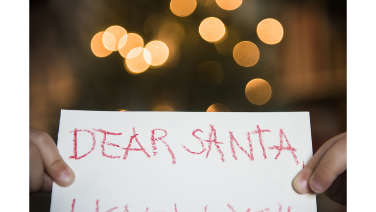 Hands of Caucasian girl holding dear Santa letter