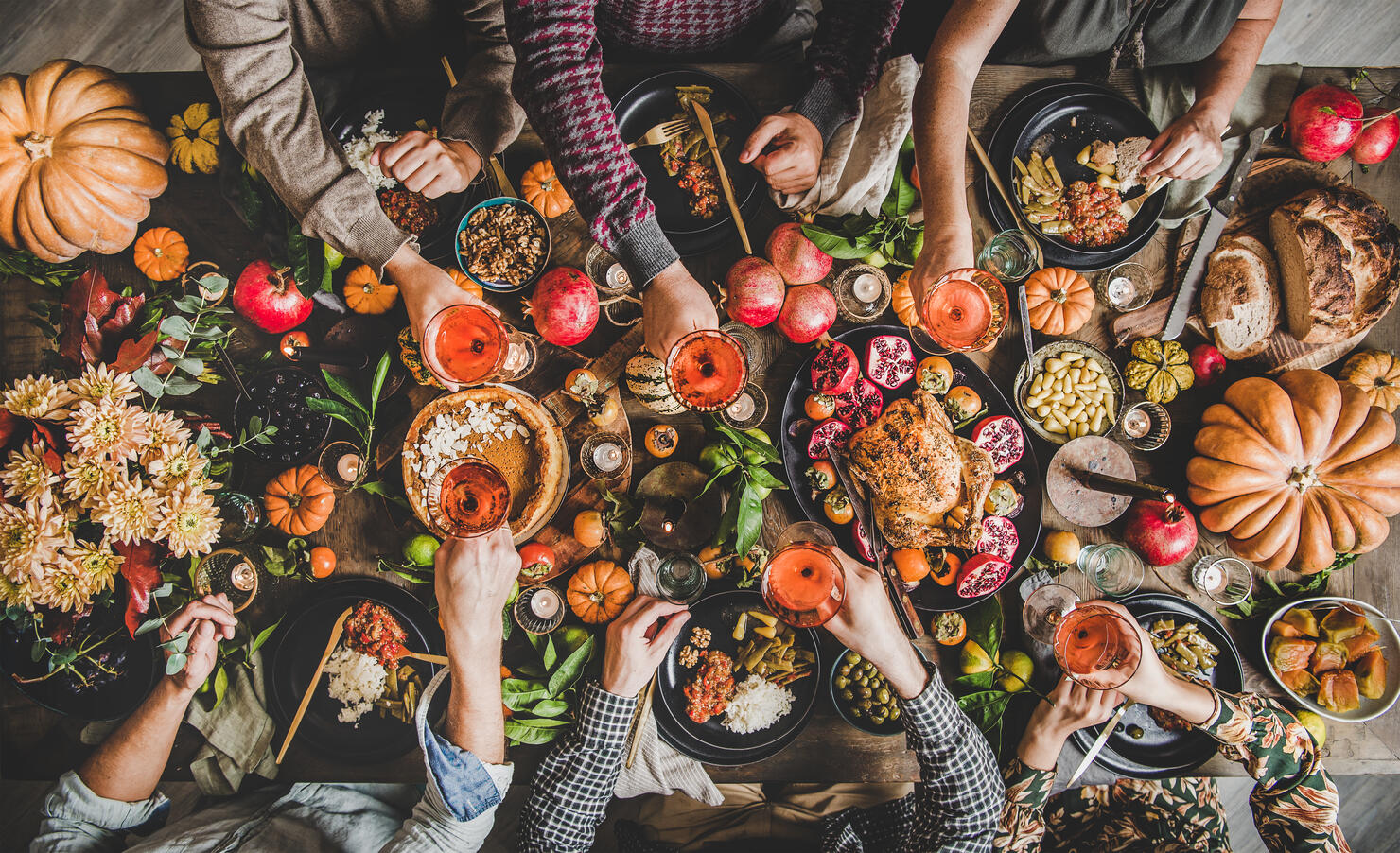 Family or friends celebrating Thanksgiving day clinking glasses with wine
