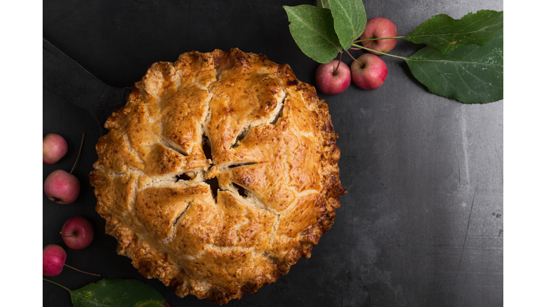 Apple pie in cast iron skillet on rustic table