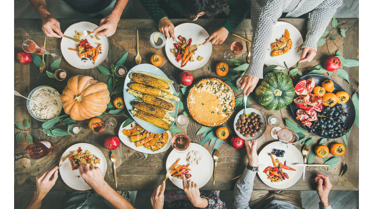 Friends eating at Thanksgiving Day table with vegetarian meals