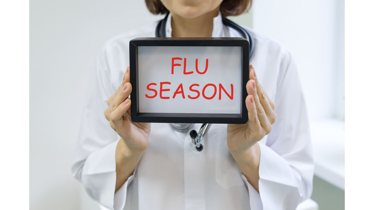 Flu season text in the hands of a female doctor