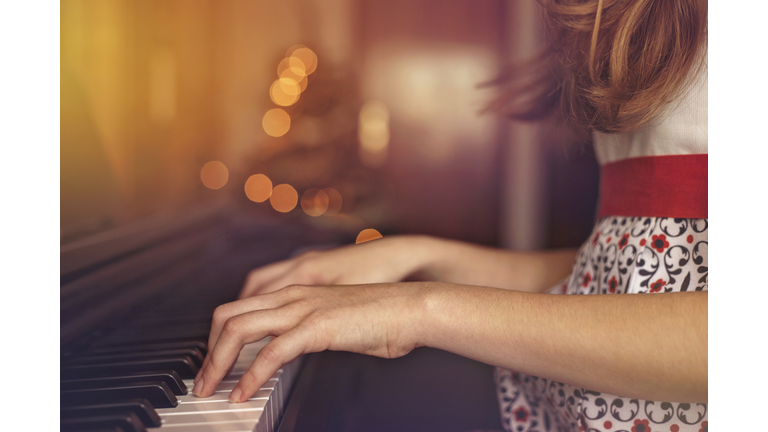 Christmas. Close up of the hands of a girl playing the piano.