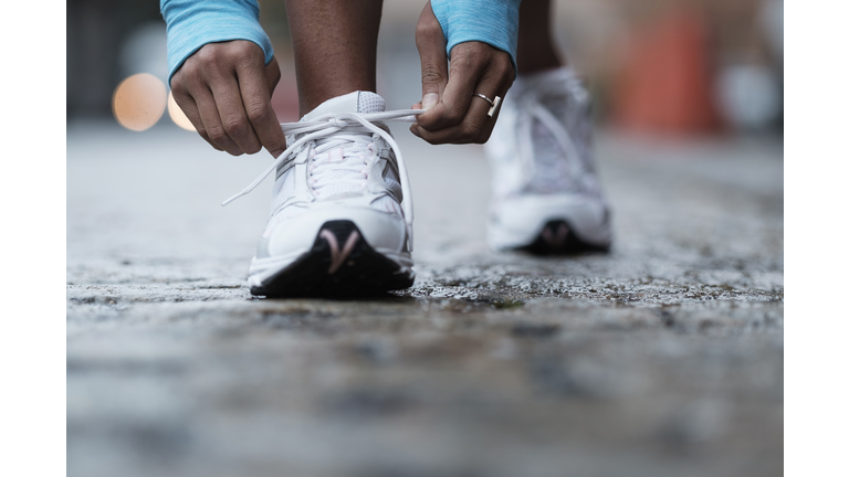 Mixed race runner tying shoelaces