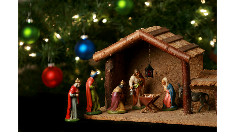 Nativity scene next to a Christmas tree