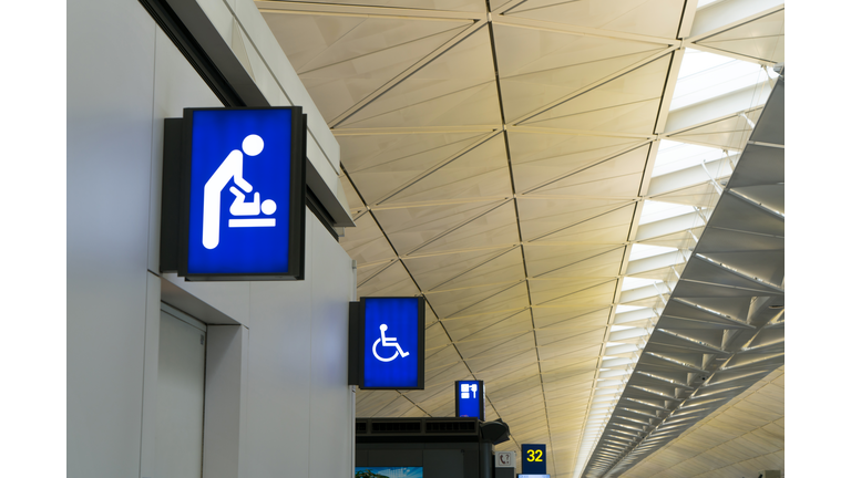 Illuminated signboard for deaper changing rooms and disabled toilet in international airport with copy space for text.