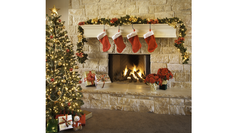 Christmas stockings, fire in fireplace, tree, and decorations