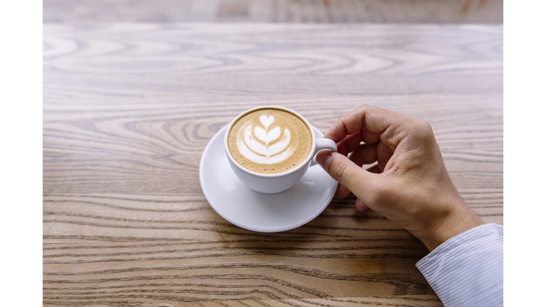 Drinking coffee at the bar counter in coffee shop, personal perspective