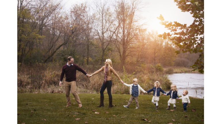 family, holding hands, walking forward in line