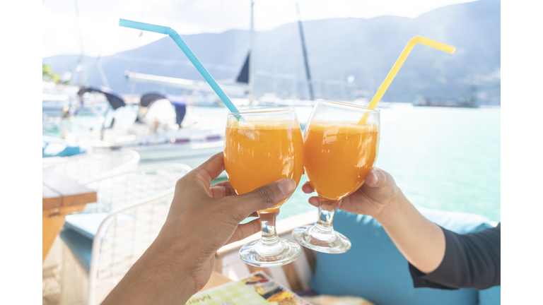 Couple toasting with cocktail on boat, Lefkada Island, Levkas, Greece