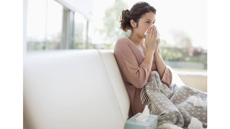 Sick woman blowing her nose