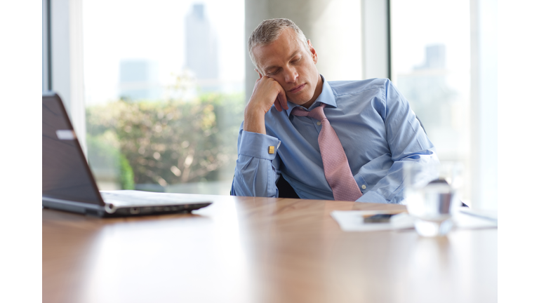 Businessman napping at desk in office