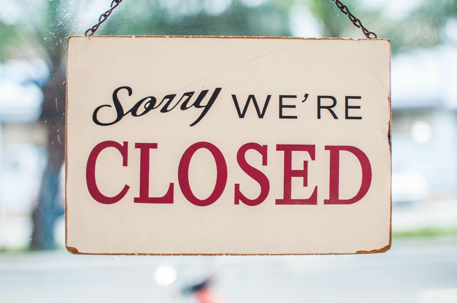 Store closed sign hanging on the window