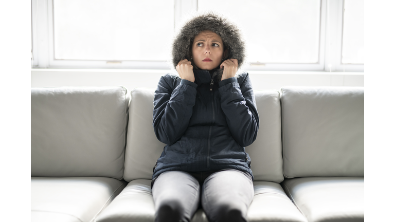 Woman have cold on the sofa at home with winter coat