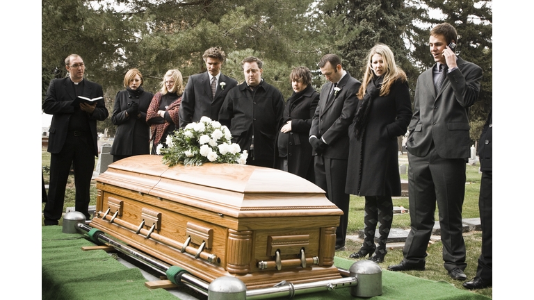 people at a funeral in a cemetery