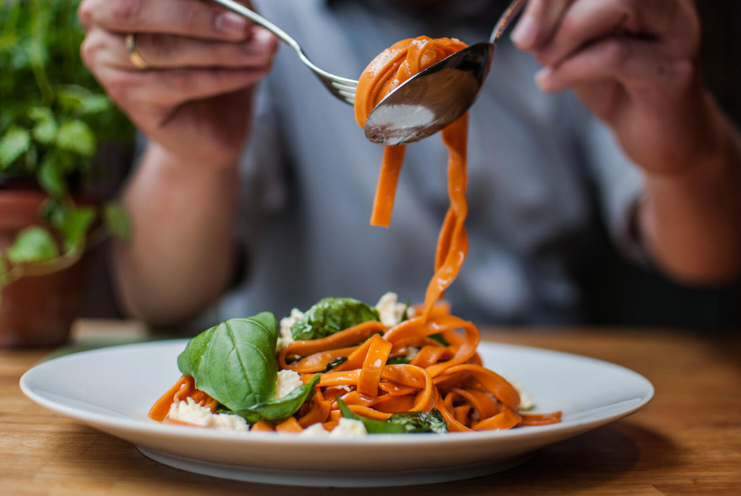 Midsection Of Man Having Pasta In Restaurant