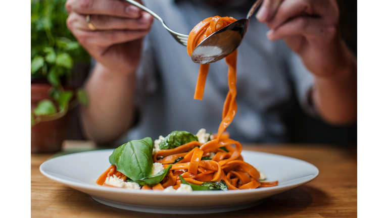 Midsection Of Man Having Pasta In Restaurant