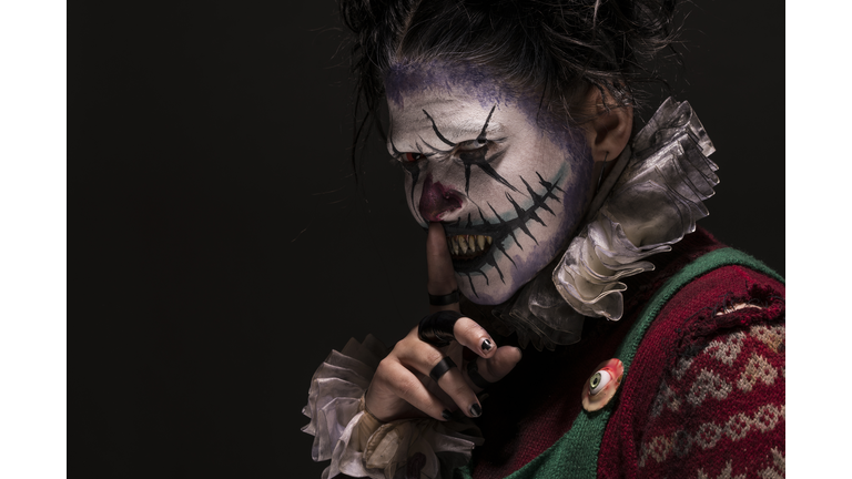 Creepy Female Clown with fingers on lips