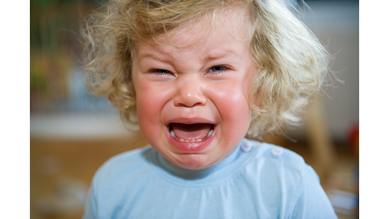 A child in a blue shirt that is crying
