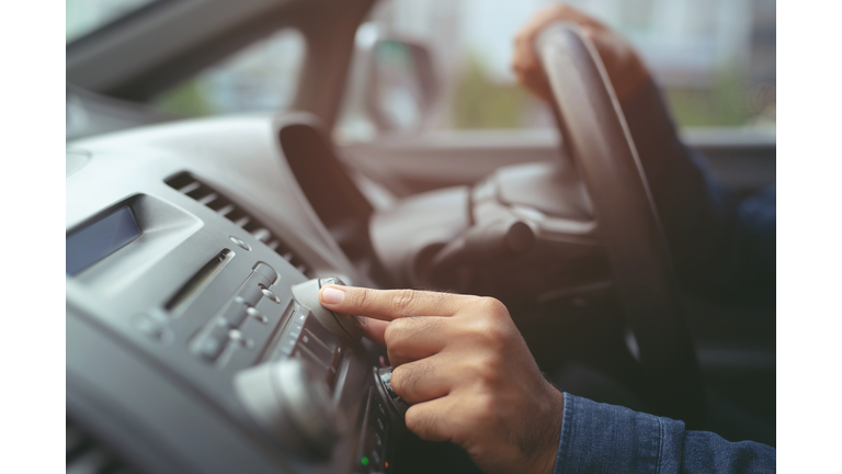 close up hand open car radio listening. Car Driver changing turning button Radio Stations on His Vehicle Multimedia System. Modern touch screen Audio stereo System. transportation and vehicle concept