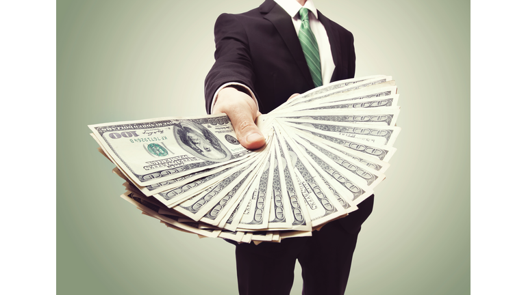 Business Man Displaying a Spread of Cash