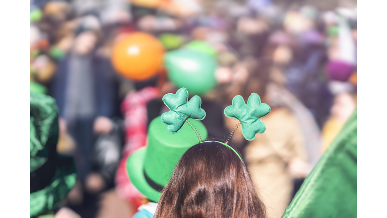 Clover head decoration on head of girl close-up. Saint Patrick day, parade in the city, selectriv focus