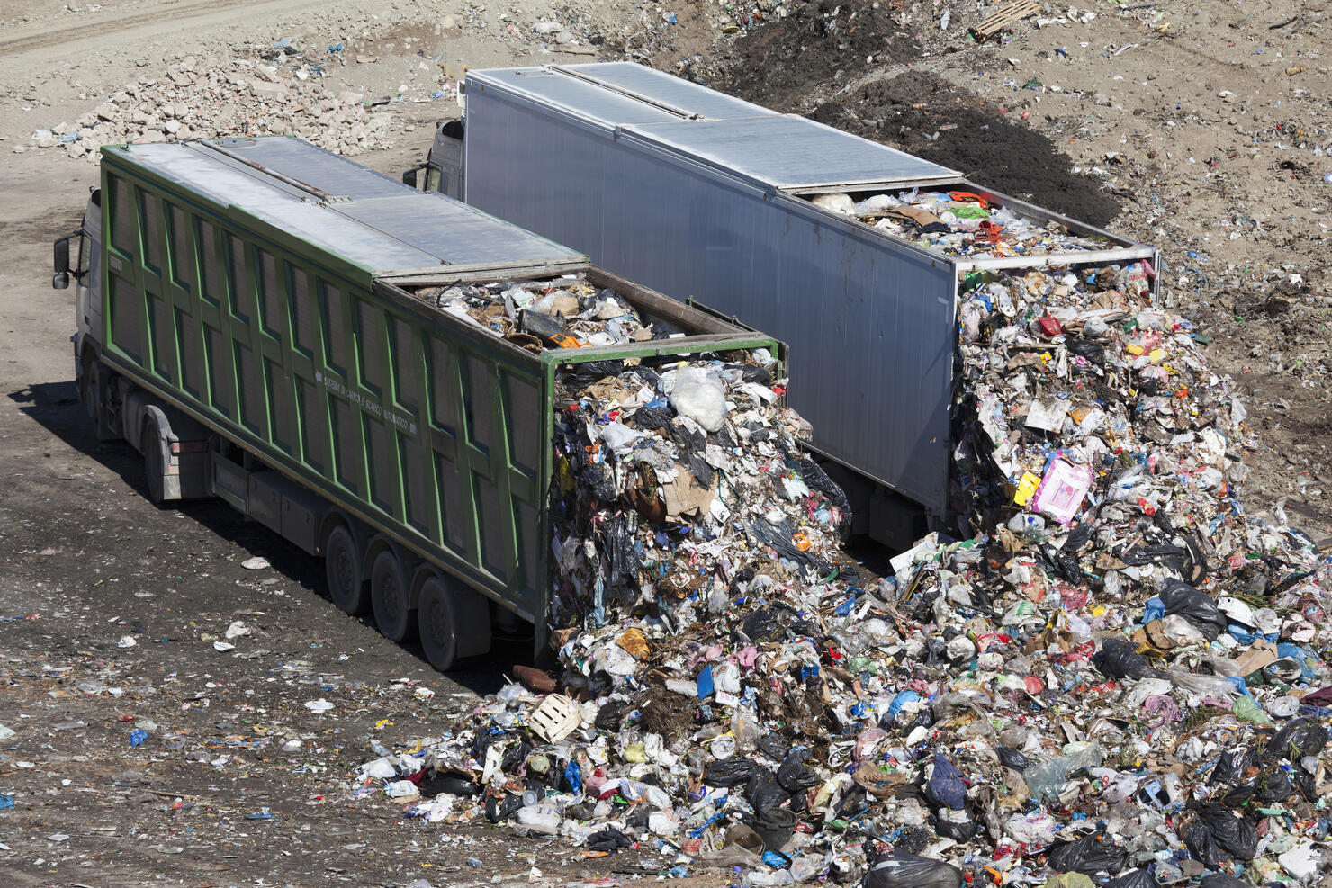 Trucks dumping waste in landfill
