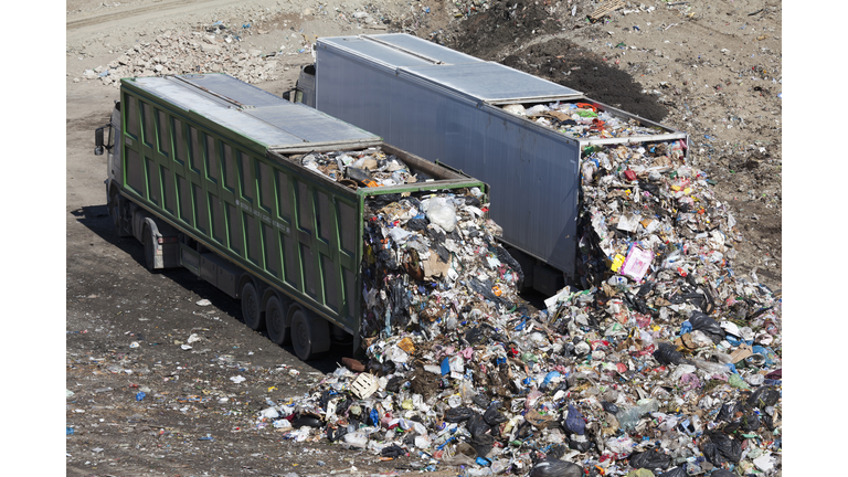 Trucks dumping waste in landfill