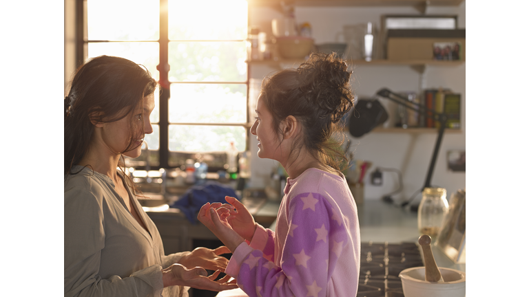 A mother and teenage daughter chatting playfully