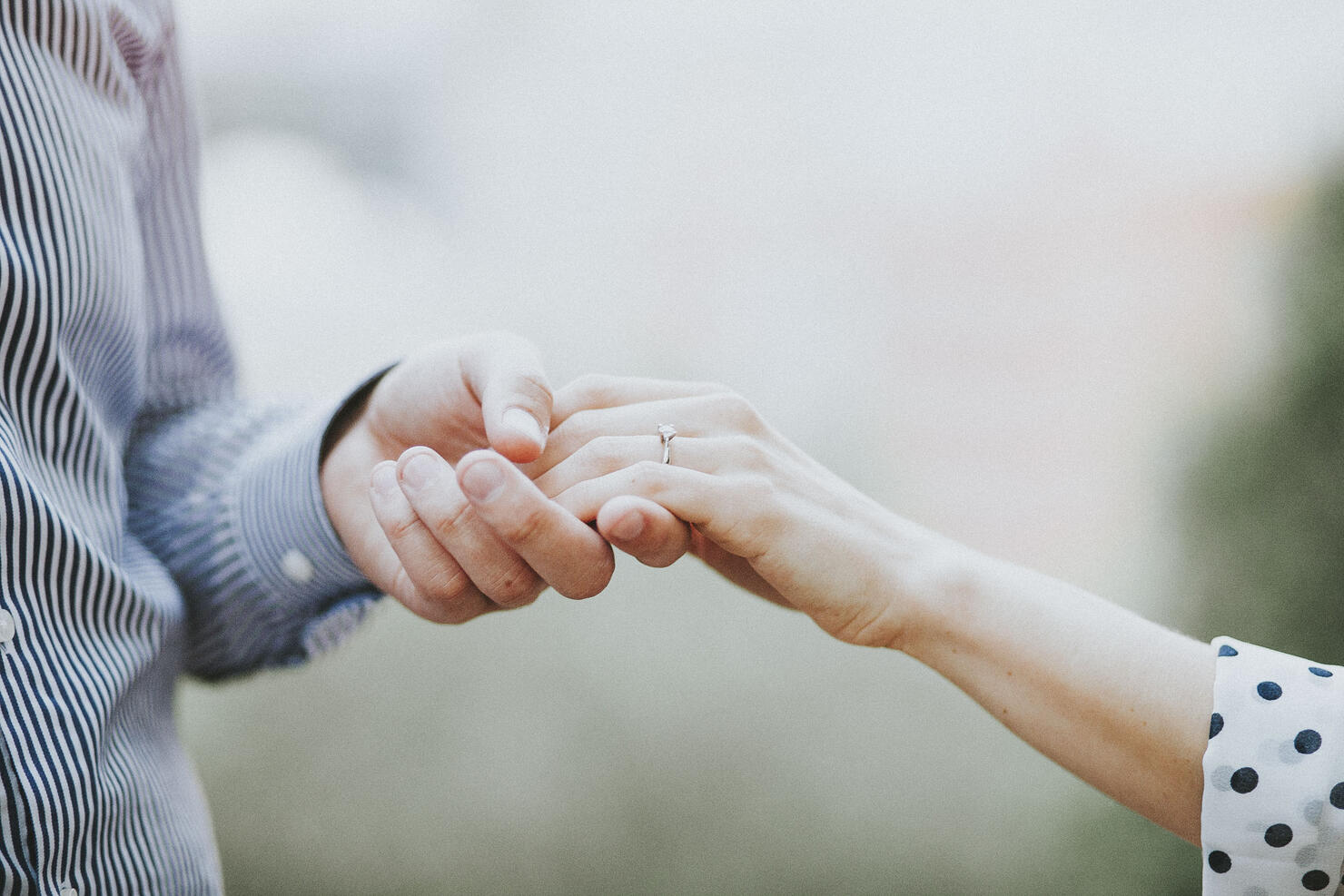 Holding hands with engagement ring, surprise proposal