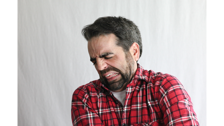 Extremely expressive guy in his late 30s: disgusted or aching
