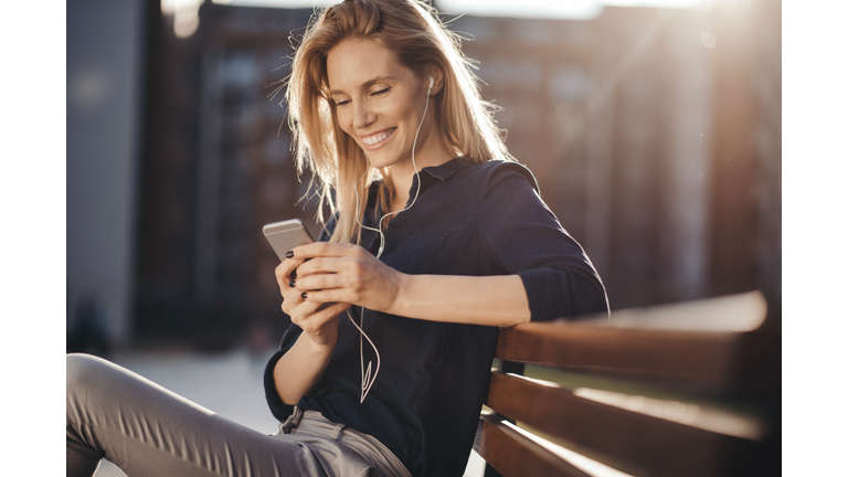 Attractive girl with headphones embracing the sunny day