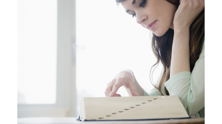 USA, New Jersey, Jersey City, Young woman reading dictionary