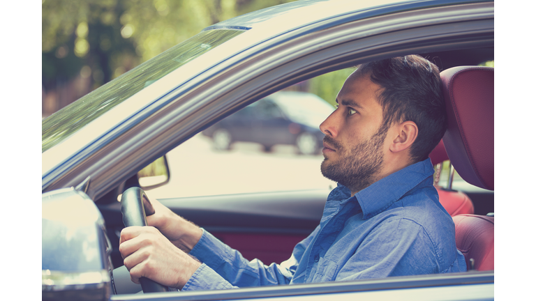 scared man driver in car. Inexperienced anxious motorist