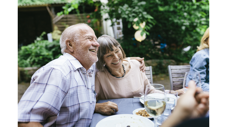 Elderly Couple Enjoying Outdoor Meal With Family