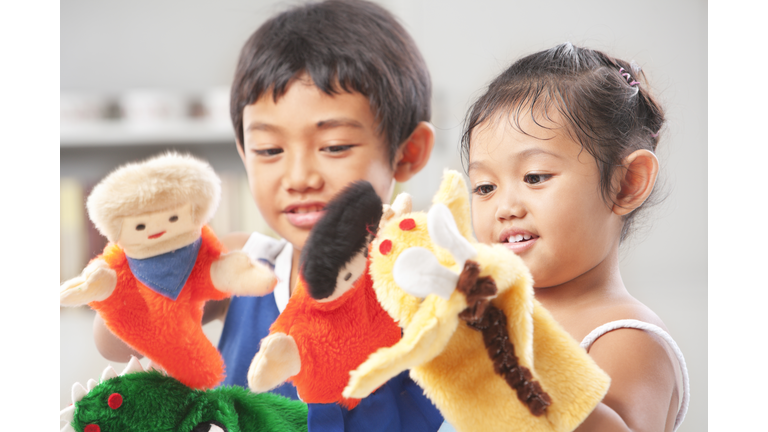 Sibling playing hand puppet