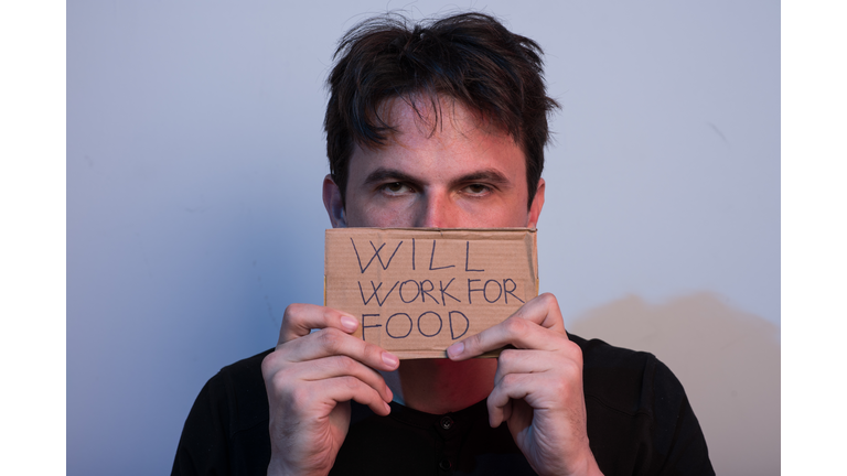 Portrait Of Man Covering Face With \will Work For Food\ Sign