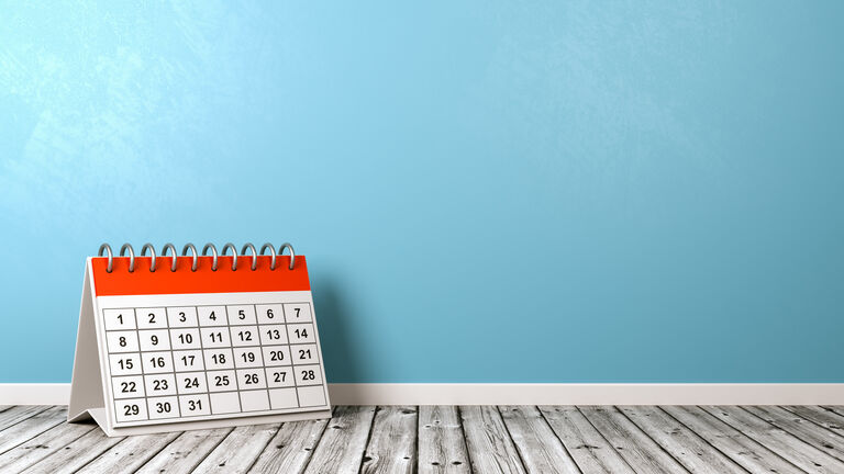 Desk Calendar on Wooden Floor Against Wall