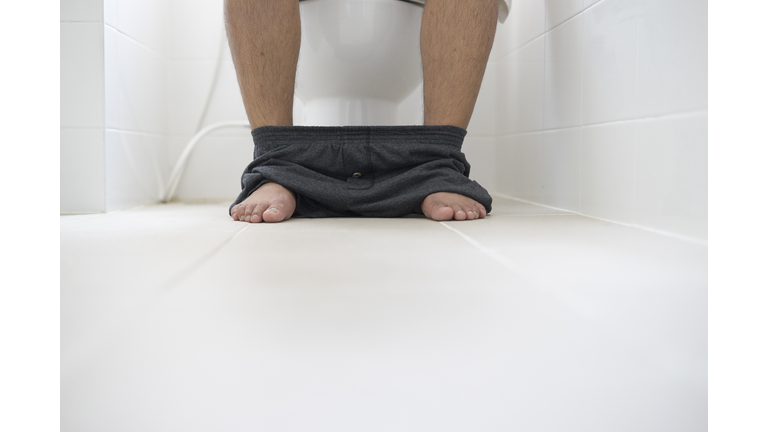 male sitting in toilet