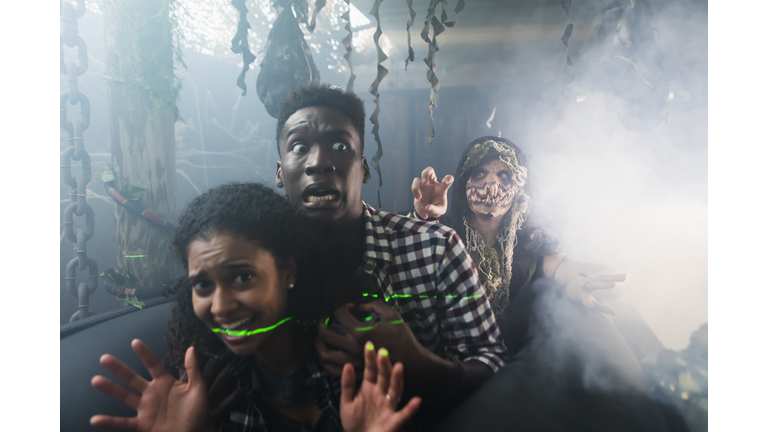 Young couple with zombie in halloween haunted house