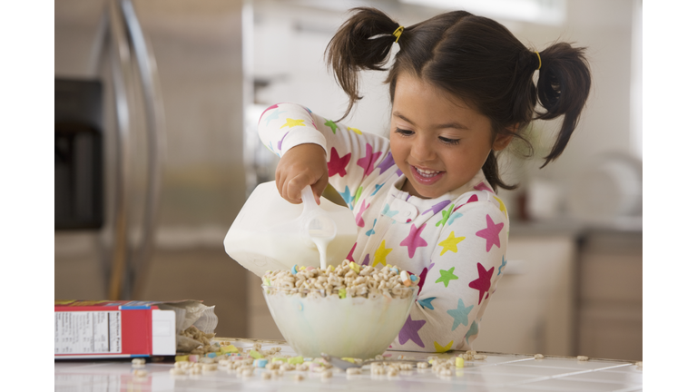 Caucasian pouring milk into cereal