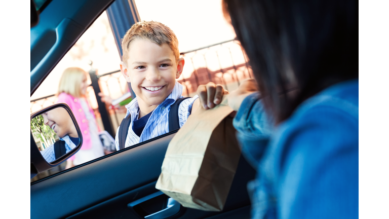 Mother gives son his lunch in carpool line at school