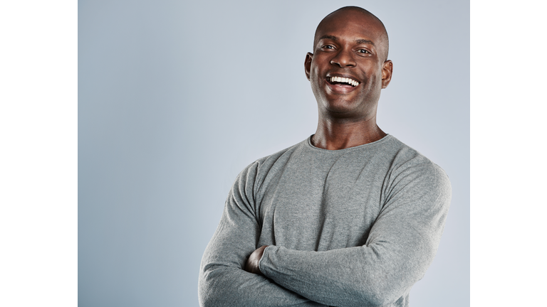 Laughing African man in gray shirt with copy space