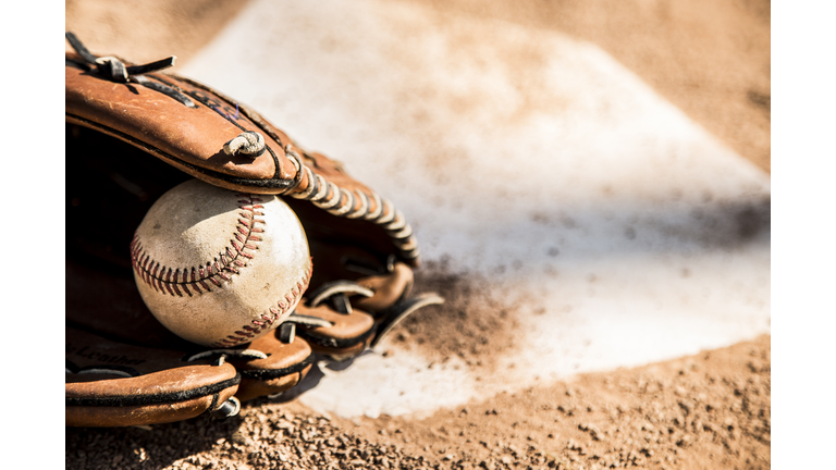 Baseball season is here.  Glove and ball on home plate.