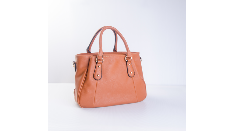 Close-Up Of Leather Purse On Table Against White Background