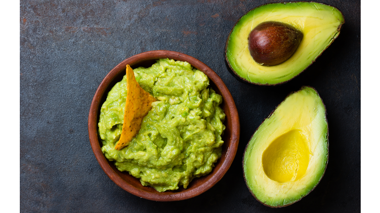 Latin American sauce guacamole and avocado sandwiches on dark background.