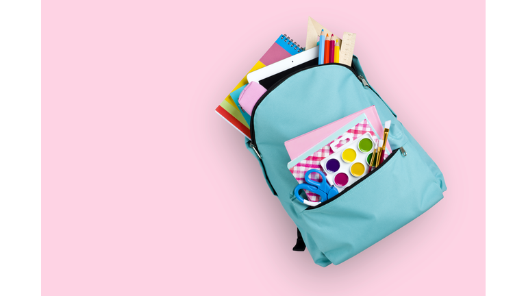 Full school backpack isolated on pink background