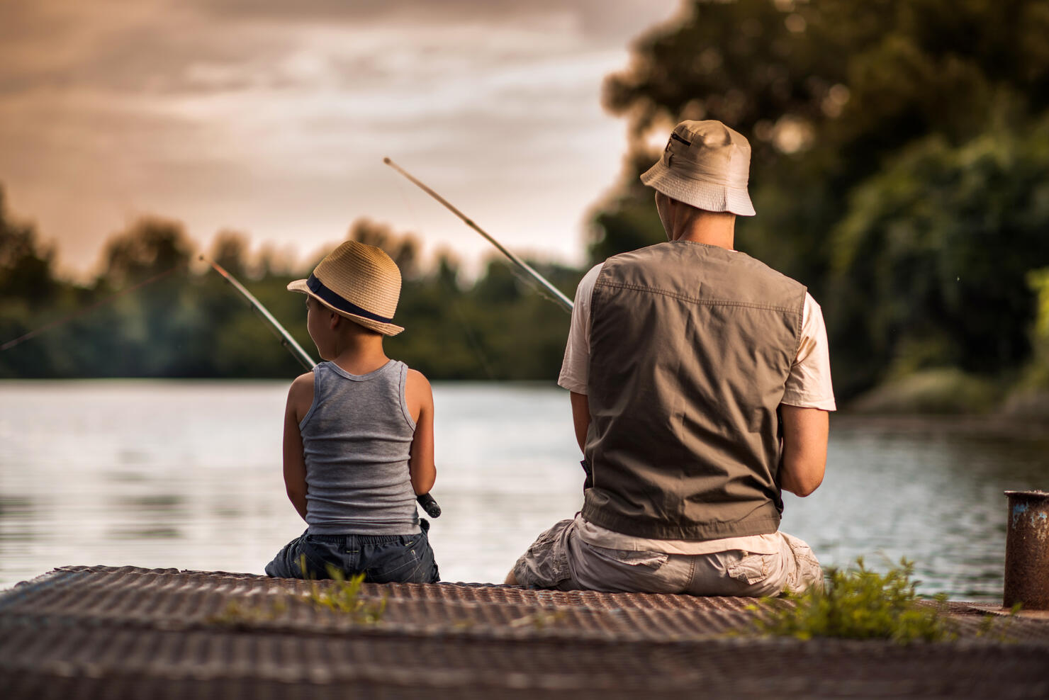 Rear view of a father and son freshwater fishing.