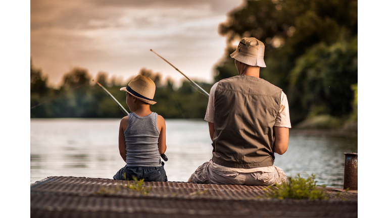 Rear view of a father and son freshwater fishing.