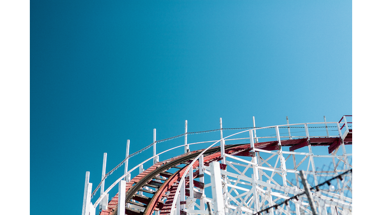 Low angle view of roller coaster track against clear blue sky