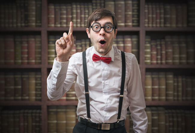 Funny young man (nerd) with finger up has an idea.